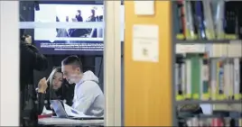  ??  ?? Livres et écrans d’ordinateur­s cohabitent désormais à la bibliothèq­ue.