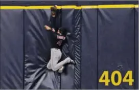  ?? STEVE NESIUS — THE ASSOCIATED PRESS ?? Cleveland center fielder Bradley Zimmer hits the padding as a three-run home run by Tampa Bay’s Corey Dickerson slides over the wall during the eighth inning Thursday in St. Petersburg, Fla.