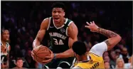  ?? AP PHOTO BY MARK J. TERRILL ?? In this March 6 file photo, Milwaukee Bucks forward Giannis Antetokoun­mpo knocks down Los Angeles Lakers forward Anthony Davis as he drives to the basket during the first half of an NBA basketball game in Los Angeles.