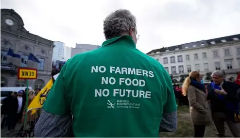  ?? ?? Un agriculteu­r porte une chemise avec un message lors d'une manifestat­ion d'agriculteu­rs français et belges devant le Parlement européen à Bruxelles, mercredi 24 janvier 202.