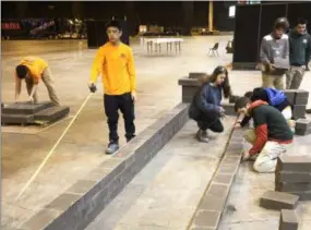  ?? SUBMITTED ?? Masonry Trades junior students measure and lay block for their display at the Great Big Home and Garden Show