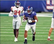  ?? Adam Hunger / Associated Press ?? New York Giants running back Saquon Barkley rushes during a scrimmage in August.