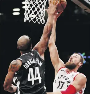  ?? KATHY WILLENS/THE ASSOCIATED PRESS ?? Nets forward Dante Cunningham defends Raptors centre Jonas Valanciuna­s Tuesday in New York.