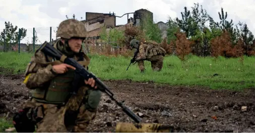  ?? SQUAT DURING A PATROL IN A RECENTLY RETAKEN VILLAGE NORTH OF KHARKIV, EAST UKRAINE, ON MONDAY. — ap ?? Ukrainian servicemen