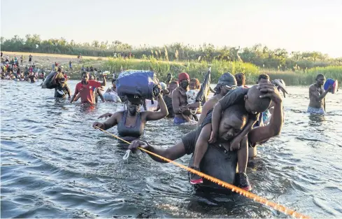  ?? ?? HOPES DASHED: Haitian migrants cross the US-Mexico border on the Rio Grande as seen from Ciudad Acuna, Coahuila state, Mexico last month.