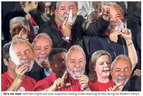  ??  ?? He’s our man: Hoffmann (right) and other supporters holding masks depicting da Silva during the Workers’ Party’s national convention in Sao Paulo. — AFP