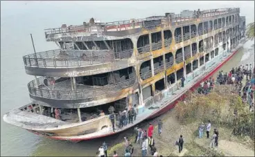  ?? REUTERS ?? The burnt passenger ferry is seen anchored on the bank of Sugandha River in Jhalalathi, Bangladesh.