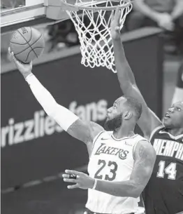 ?? WADE PAYNE AP ?? The Lakers’ LeBron James, who had 22 points, 13 rebounds and eight assists, shoots past Grizzlies center Gorgui Dieng during the first half Sunday.