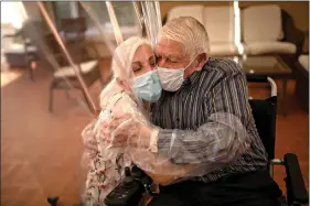  ?? (AP Photo/Emilio Morenatti) ?? Dolores Reyes Fernández, 61, hugs her father, José Reyes Lozano, 87, for the first time in nearly four months as visits resume June 22 at Ballesol Puig i Fabra nursing home in Barcelona, Spain.