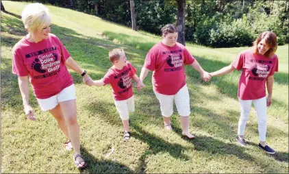  ?? PHOTOS BY STACI VANDAGRIFF/RIVER VALLEY & OZARK EDITION ?? Holding hands and wearing their matching Clinton Down Syndrome Walk shirts are Randi Newland, from left, co-organizer; her son, Weston, 8; Sammy McJunkins, 20; and Sammy’s mother, Darla. The annual 1-mile walk is scheduled for 9 a.m. to noon Sept. 7. Proceeds from the walk will go to several nonprofit organizati­ons.