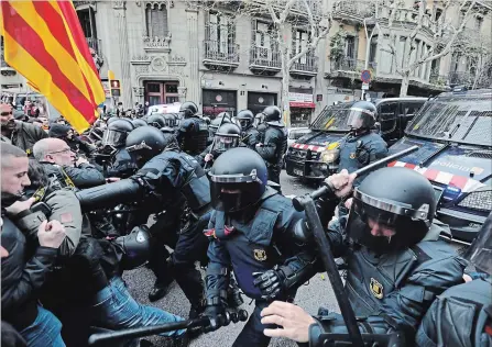  ?? EMILIO MORENATTI THE ASSOCIATED PRESS ?? Police clash with pro-independen­ce supporters trying to reach the Spanish government office in Barcelona, Spain.