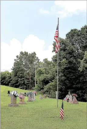  ?? MEGAN DAVIS/MCDONALD COUNTY PRESS ?? Small U.S. flags denote the graves of military veterans buried in Pineville Cemetery. Many of the graves were colorfully adorned following Decoration Day 2016.