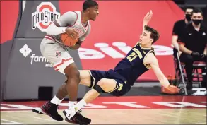  ?? Jamie Sabau / Getty Images ?? Michigan’s Franz Wagner draws a foul on Ohio State’s E.J. Liddell in the second half on Sunday in Columbus, Ohio. Michigan defeated Ohio State 92-87.