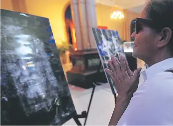  ??  ?? IGLESIA. Leda Díaz apreció el rostro de Jesucristo en la exposición del Sudario.