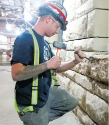  ?? JIM WELLS/FILES ?? A worker removes damaged sandstone at old city hall.