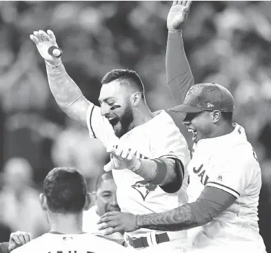  ?? FRANK GUNN / THE CANADIAN PRESS ?? Toronto outfielder Kevin Pillar celebrates his walk-off, game-winning homer against the Seattle Mariners with his teammates Sunday at the Rogers Centre. The 3-2 victory was the Jays fifth straight and 15th in their last 25 games.