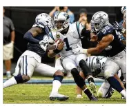  ?? FOSTER III / CHARLOTTE OBSERVER DAVID T. ?? Panthers quarterbac­k Cam Newton rolls out of pressure from Cowboys defensive end Tyrone Crawford (98) during the first half on Sunday in Charlotte, N.C.