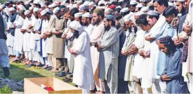  ?? Associated Press ?? ↑ People pray during the funeral of Bilal Khan in Abbotabad, Khyber Pakhtunkhw­a province, on Monday.