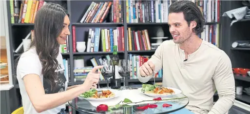  ?? RICHARD LAUTENS TORONTO STAR ?? Astrid Loch and Kevin Wendt, who met on a reality TV show, sit down for a pre-Valentine’s pasta and salad dinner the two prepared in the Star’s test kitchen.