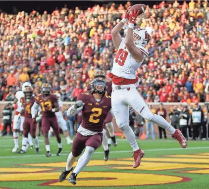  ?? MIKE DE SISTI / MILWAUKEE JOURNAL SENTINEL ?? Wisconsin tight end Kyle Penniston catches a touchdown pass over Minnesota defensive back Jacob Huff during the second quarter Saturday in Minneapoli­s.