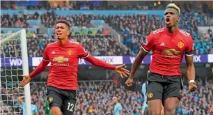  ?? AFP ?? Manchester United’s Chris Smalling and Paul Pogba celebrate a goal against Manchester City. —