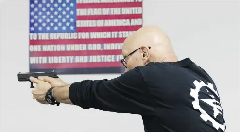  ?? LYNNE SLADKY / THE ASSOCIATED PRESS ?? Mike Weinstein, director of training and security at the National Armory gun store and gun range, shows how to safely fire a Glock 9mm hand gun during a concealed-weapons permit class on Tuesday in Pompano Beach, Fla.