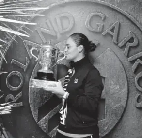  ?? Clive Brunskill, Getty Images ?? Ashleigh Barty kisses the trophy as she celebrates her victory Saturday against Marketa Vondrousov­a for the French Open title.