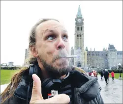  ?? CP PHOTO ?? Denis Marcoux of Ottawa smokes a marijuana joint on Parliament Hill in Ottawa on Wednesday.