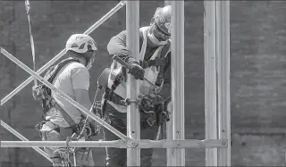  ?? NEW YORK
-AP ?? Constructi­on workers assemble a scaffold at a job site, as phase one of reopening after lockdown begins, during the outbreak of the coronaviru­s disease in US.