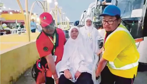  ??  ?? Tabung Haji’s Highway Emergency Patrol Team members helping an elderly pilgrim in Makkah.