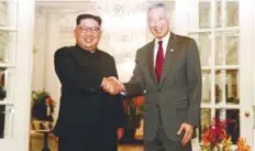  ??  ?? Kim ( shakes hands with Prime Minister Lee at the Istana.