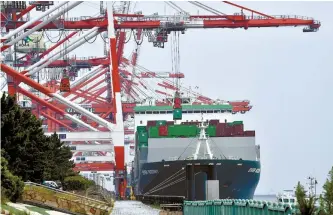  ?? AFP-Yonhap ?? A crane unloads a container from a cargo ship at the internatio­nal cargo terminal at the port in Tokyo in this Aug. 19 file photo.