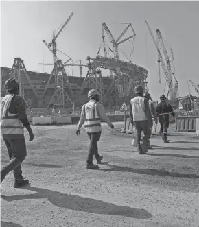  ?? HASSAN AMMAR/AP FILE ?? Migrant laborers who built Qatar’s World Cup stadiums often worked long hours under harsh conditions and were subjected to discrimina­tion, wage theft and other abuses, a rights group said.