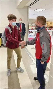  ?? PHOTO COURTESY OF RACHEL JONES ?? Russellvil­le High School sophomore Gabriel Hogue, left, shakes hands recently with newly hired head football coach David Wheeler. Wheeler replaces former head coach Jeff Weaver, who resigned in November.