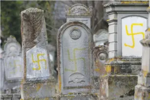  ?? (Vincent Kessler/Reuters) ?? GRAVES THAT WERE DESECRATED with swastikas are seen at the Jewish cemetery in Quatzenhei­m, France.