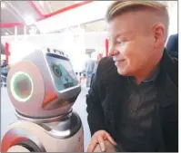  ?? XINHUA ?? A visitor interacts with a nursing robot at the China Internatio­nal Silver Industry Summit Forum in Beijing.