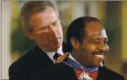  ?? THE ASSOCIATED PRESS ?? President Bush awards Paul Rusesabagi­na, who sheltered people at a hotel he managed during the 1994 Rwandan genocide, the Presidenti­al Medal of Freedom Award in 2005. A well-known critic of the Rwandan government, Rusesabagi­na has been arrested on terror charges.