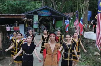  ?? ?? Youths from the Dusun Liwan Ranau tribe welcoming visitors to the Sungai Moroli Tagal in Ranau. — Bernama photo
