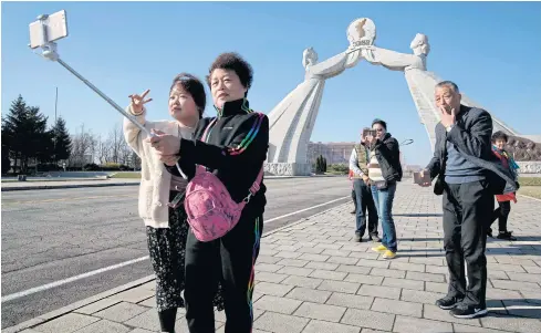  ?? AFP ?? In a photo taken on April 14, 2019, tourists from China pose for photos before the Three Charters monument in Pyongyang.
