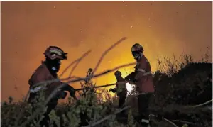  ?? BILD: SN/AP ?? Feuerwehrl­eute bekämpfen einen Brand außerhalb von Óbidos.