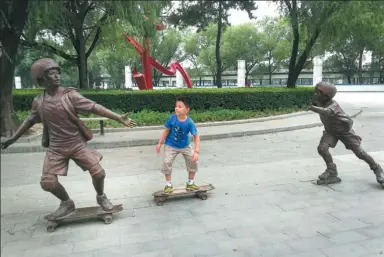  ?? LIANG GUOZHUANG / FOR CHINA DAILY ?? A boy poses for photos with sculptures at a square in Beijing on Sunday.