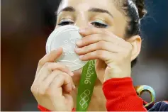  ??  ?? File photo of Aly Raisman looking at her silver medal on the podium during the 2016 Rio Olympics. — Reuters photo