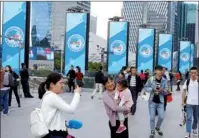  ?? PHOTOS BY GAO ERQIANG / CHINA DAILY ?? Left and Center: Logos and mascots of the upcoming China Internatio­nal Import Expo are seen on the streets in Shanghai. Right: Workers perform landscapin­g at the National Exhibition and Convention Center (Shanghai).