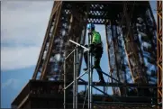  ?? (AP PHOTO/THOMAS PADILLA) ?? A workers builds the stands for the upcoming summer Olympic Games on the Champ-de-mars just beside the Eiffel Tower, in Paris, Monday, April 1, 2024 in Paris. The Paris 2024 Olympic Games will run from July 26 to Aug.11, 2024.