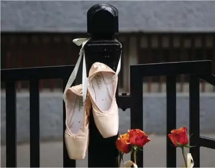  ?? ?? Ballet shoes are seen hanging on the fence of the Vladislav Ribnikar school in Belgrade, Serbia, Thursday, May 4, 2023. Police say a 13-year-old who opened fire at his school drew sketches of classrooms and made a list of people he intended to target. He killed eight fellow students and a school guard before being arrested. Photo: AP/Armin Durgut.