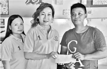  ??  ?? Loh (centre) hands over a RM10,000 cheque to Wong while UPP Dudong Women Section secretary Karen Cho looks on.