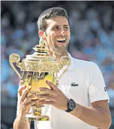  ??  ?? Gesture: Novak Djokovic lifts the trophy as Wimbledon Men’s Champion 2018