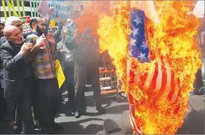  ?? AP PHOTO ?? Iranian protestors burn a representa­tion of a U.S. flag during a gathering after their Friday prayer in Tehran, Iran, Friday.