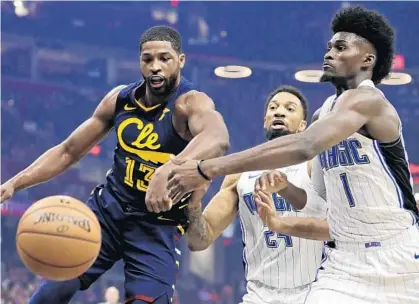  ?? TONY DEJAK/AP ?? The Magic’s Jonathan Isaac, right, battles the Cavaliers’ Tristan Thompson for possession of the ball Friday night in Cleveland.