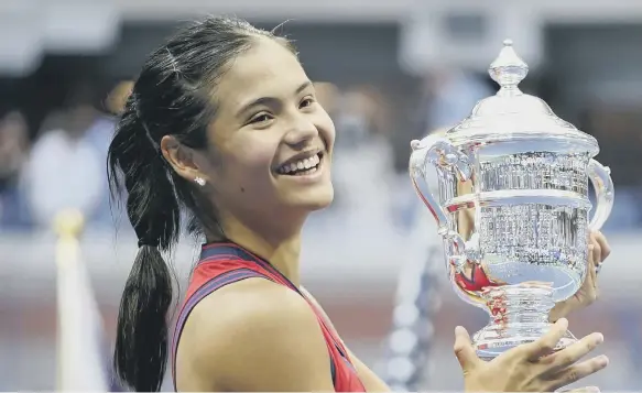  ??  ?? Great Britain’s Emma Raducanu holds the trophy as she celebrates winning the women’s singles final at the US Open.